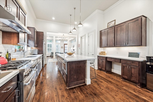 1035 Waverly St Unit B, Houston, TX 77008 - kitchen featuring under cabinet range hood, appliances with stainless steel finishes, crown molding, dark wood-style floors, and dark brown cabinetry