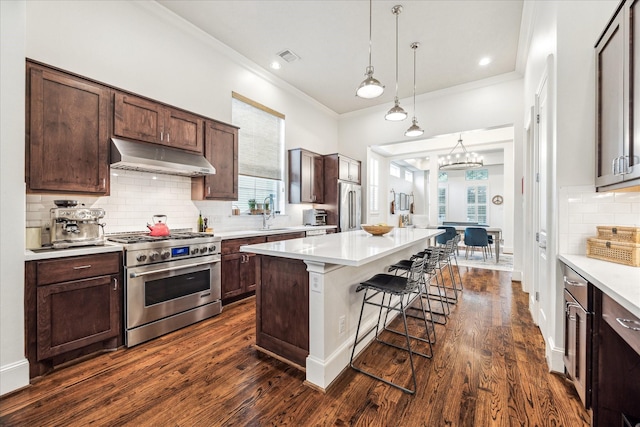 1035 Waverly St Unit B, Houston, TX 77008 - kitchen featuring high quality appliances, under cabinet range hood, a breakfast bar, crown molding, and light countertops