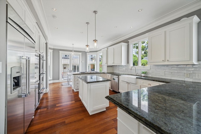 2317 Ashland St, Houston, TX 77008 - kitchen with appliances with stainless steel finishes, crown molding, dark wood finished floors, a peninsula, and tasteful backsplash