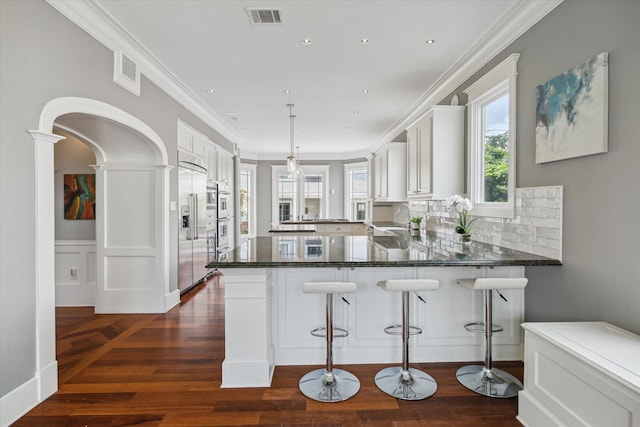 2317 Ashland St, Houston, TX 77008 - kitchen with a peninsula, dark wood finished floors, built in refrigerator, white cabinetry, and recessed lighting