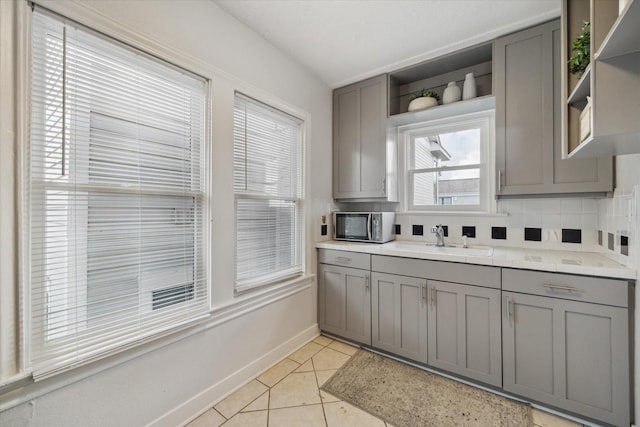 2317 Ashland St, Houston, TX 77008 - kitchen with open shelves, gray cabinetry, light tile patterned floors, and light countertops