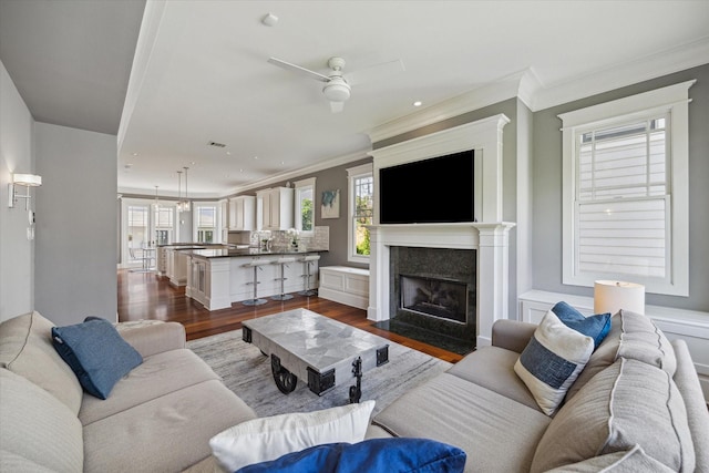 2317 Ashland St, Houston, TX 77008 - living room featuring dark wood finished floors, a ceiling fan, crown molding, a fireplace with flush hearth, and recessed lighting