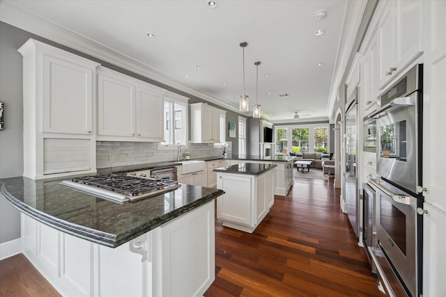 2317 Ashland St, Houston, TX 77008 - kitchen with a peninsula, stainless steel appliances, open floor plan, dark wood-style floors, and white cabinetry