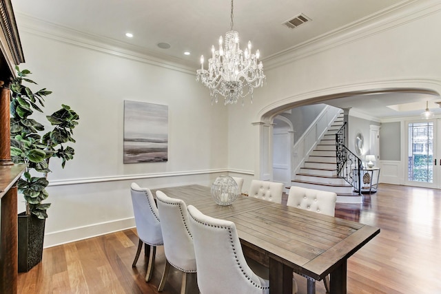 2317 Ashland St, Houston, TX 77008 - dining space featuring arched walkways, wood finished floors, crown molding, decorative columns, and a chandelier