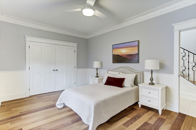 2317 Ashland St, Houston, TX 77008 - bedroom with light wood-style flooring, a wainscoted wall, ornamental molding, a closet, and a ceiling fan