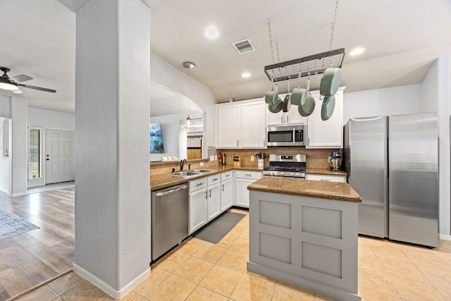 2715 Lexington Park Dr, Spring, TX 77373 - kitchen featuring stainless steel appliances, a kitchen island, tasteful backsplash, white cabinetry, and a ceiling fan