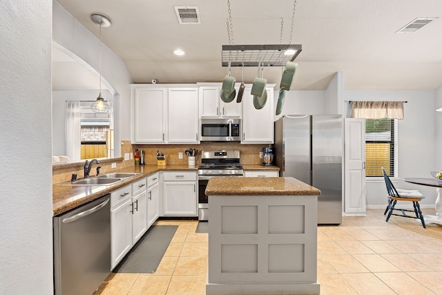 2715 Lexington Park Dr, Spring, TX 77373 - kitchen featuring appliances with stainless steel finishes, light tile patterned flooring, backsplash, a center island, and recessed lighting