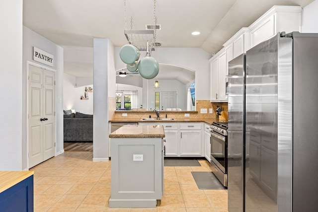 2715 Lexington Park Dr, Spring, TX 77373 - kitchen featuring appliances with stainless steel finishes, vaulted ceiling, decorative backsplash, ceiling fan, and white cabinetry