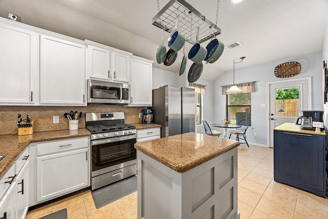 2715 Lexington Park Dr, Spring, TX 77373 - kitchen with appliances with stainless steel finishes, decorative backsplash, light tile patterned floors, a kitchen island, and light stone countertops