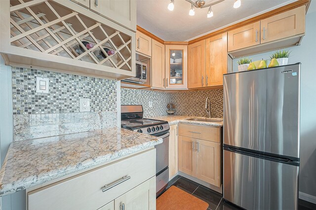 6102 Seawall Blvd Unit 252, Galveston, TX 77551 - kitchen featuring stainless steel appliances, tasteful backsplash, glass insert cabinets, light brown cabinets, and light stone countertops