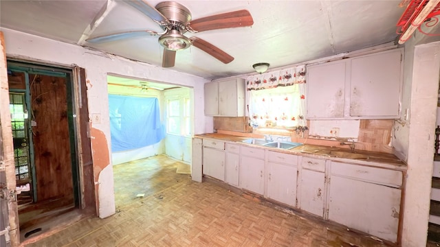 3307 Omega St, Houston, TX 77022 - kitchen featuring light countertops, a ceiling fan, and white cabinets