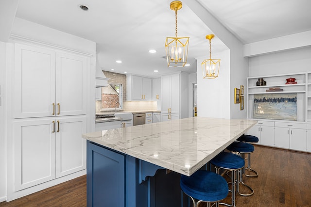 12215 Cobblestone Dr, Houston, TX 77024 - kitchen with white cabinets, dark wood finished floors, a chandelier, backsplash, and recessed lighting
