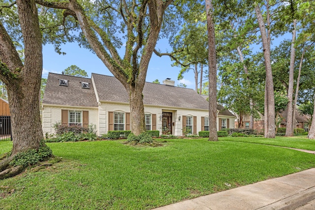 12215 Cobblestone Dr, Houston, TX 77024 - view of front of property with a front lawn, brick siding, a chimney, and roof with shingles