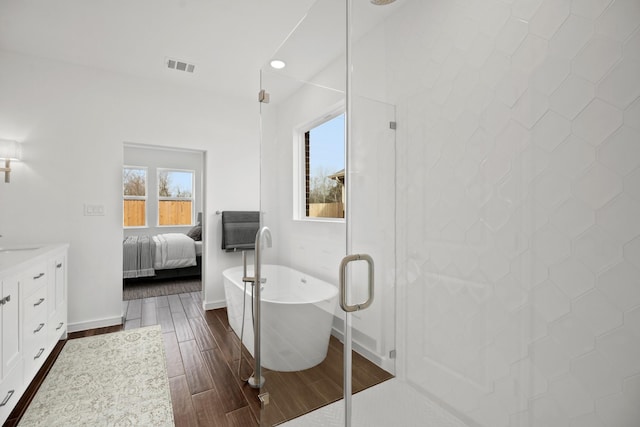 21218 Blue Bluff Dr, Cypress, TX 77433 - full bathroom featuring wood finished floors, vanity, a freestanding bath, connected bathroom, and a shower stall