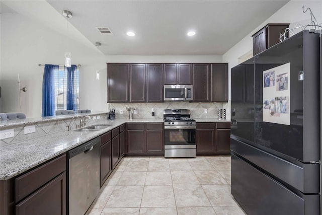 3218 Camelia Chase Ct, Spring, TX 77373 - kitchen featuring stainless steel appliances, tasteful backsplash, dark brown cabinetry, light stone countertops, and vaulted ceiling