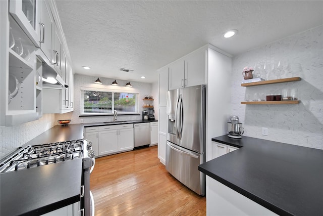 2007 Wakefield Dr, Houston, TX 77018 - kitchen featuring stainless steel appliances, open shelves, dark countertops, white cabinetry, and a textured ceiling