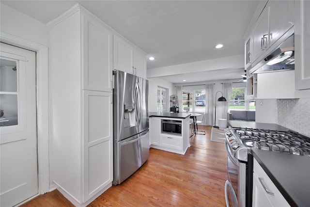 2007 Wakefield Dr, Houston, TX 77018 - kitchen with stainless steel appliances, dark countertops, white cabinetry, under cabinet range hood, and recessed lighting