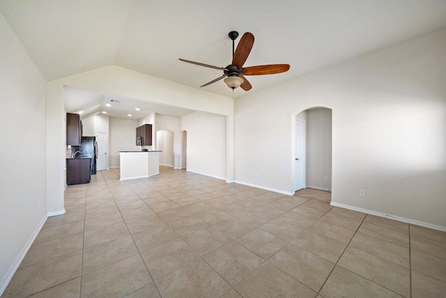 19842 Haven Cliff Ln, Cypress, TX 77433 - unfurnished living room with arched walkways, a ceiling fan, light tile patterned floors, vaulted ceiling, and recessed lighting