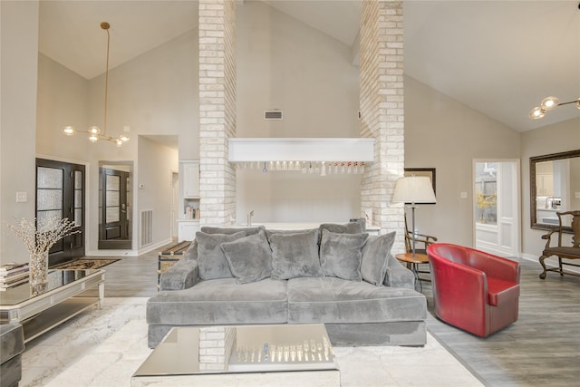 6510 Preston Trail Dr, Houston, TX 77069 - living room featuring high vaulted ceiling, ornate columns, a chandelier, and wood finished floors