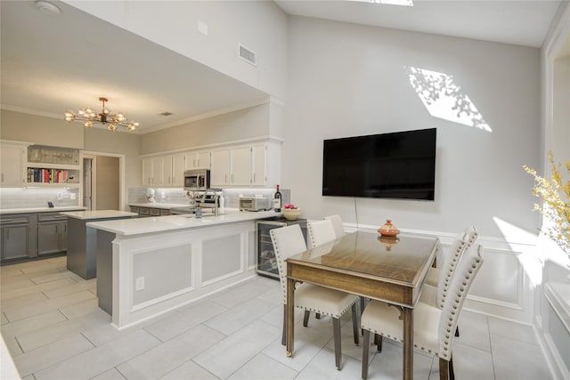 6510 Preston Trail Dr, Houston, TX 77069 - kitchen with a chandelier, stainless steel appliances, a peninsula, light countertops, and tasteful backsplash