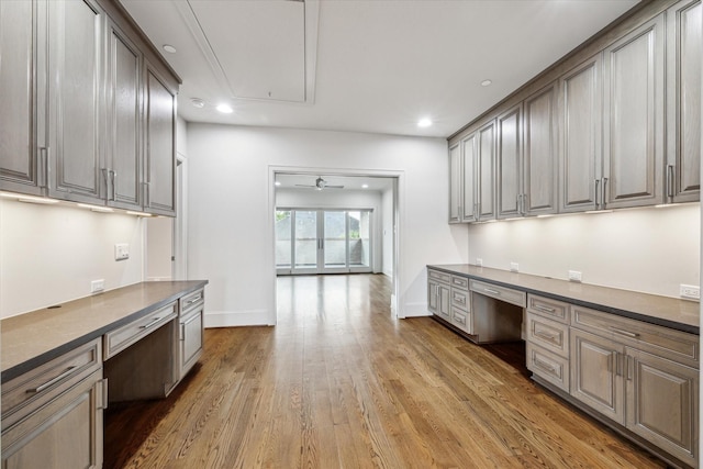 4615 Verone St, Bellaire, TX 77401 - kitchen with built in desk, dark countertops, light wood-style flooring, a ceiling fan, and recessed lighting
