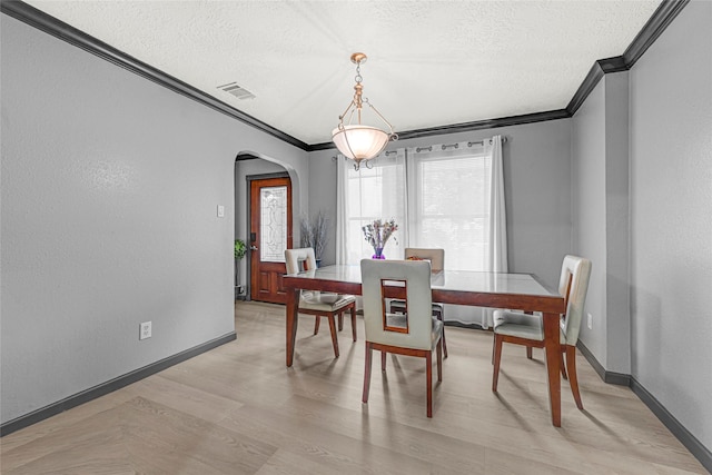 17103 Scuttle Way, Crosby, TX 77532 - dining area with crown molding, arched walkways, a textured ceiling, and light wood finished floors