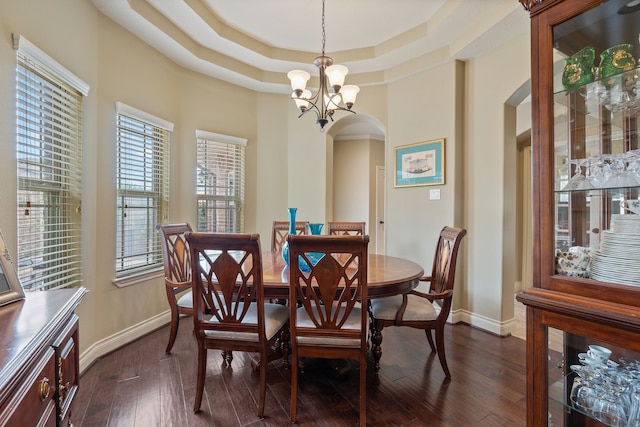 111 Bessie Price Owen Dr, Montgomery, TX 77356 - dining area with arched walkways, a raised ceiling, a chandelier, and dark wood-style flooring