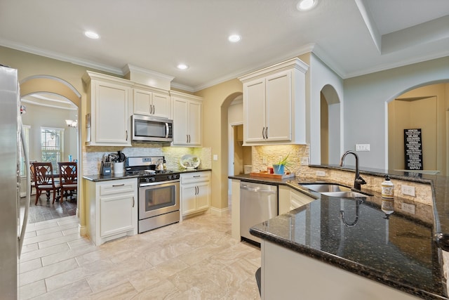 111 Bessie Price Owen Dr, Montgomery, TX 77356 - kitchen with stainless steel appliances, crown molding, dark stone counters, tasteful backsplash, and recessed lighting