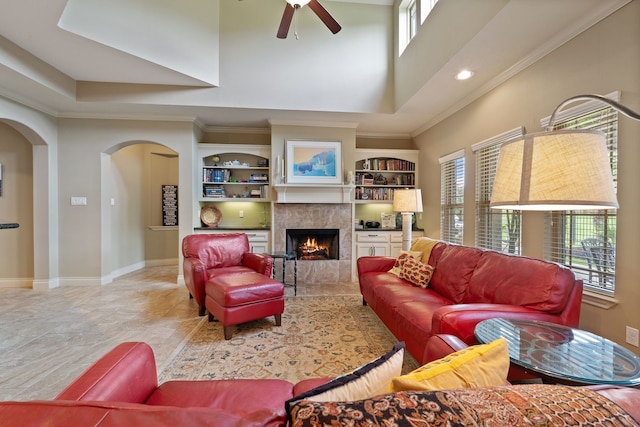 111 Bessie Price Owen Dr, Montgomery, TX 77356 - living room featuring arched walkways, crown molding, a ceiling fan, a lit fireplace, and recessed lighting