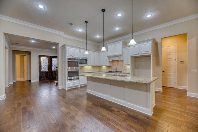 107 Lake View Loop, Fulshear, TX 77441 - kitchen with appliances with stainless steel finishes, dark wood-style floors, tasteful backsplash, light stone counters, and white cabinetry