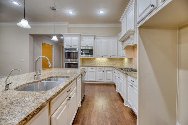 107 Lake View Loop, Fulshear, TX 77441 - kitchen with appliances with stainless steel finishes, dark wood-style flooring, white cabinetry, tasteful backsplash, and ornamental molding