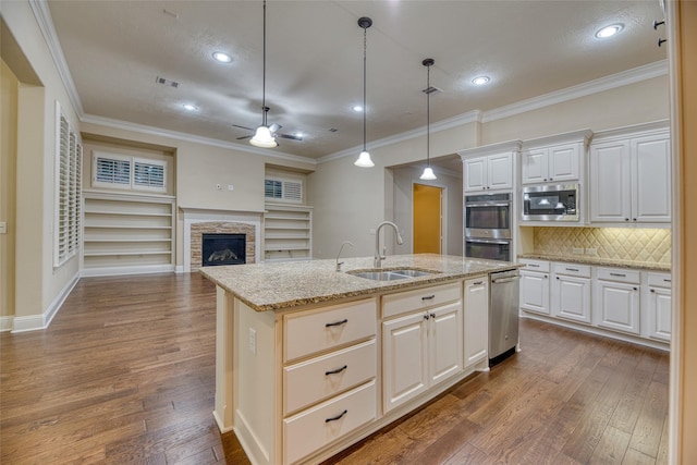 107 Lake View Loop, Fulshear, TX 77441 - kitchen featuring ceiling fan, appliances with stainless steel finishes, dark wood finished floors, an island with sink, and backsplash