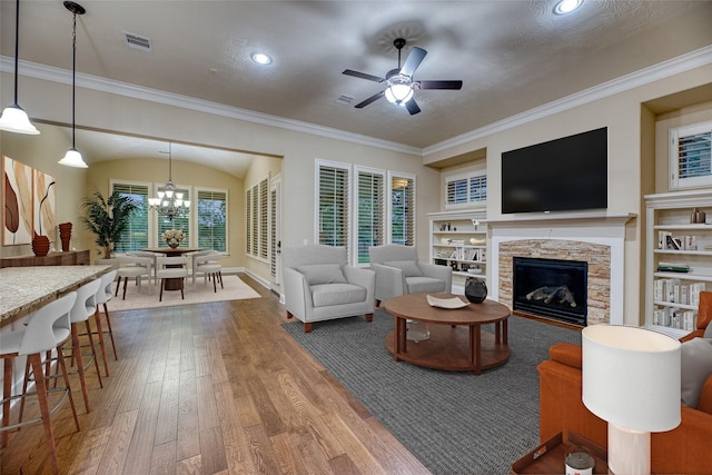 107 Lake View Loop, Fulshear, TX 77441 - living room featuring hardwood / wood-style flooring, a fireplace, a chandelier, a ceiling fan, and built in shelves