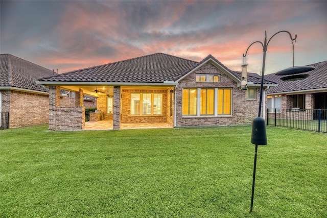 107 Lake View Loop, Fulshear, TX 77441 - back of house at dusk with brick siding, a tile roof, a patio, and a ceiling fan