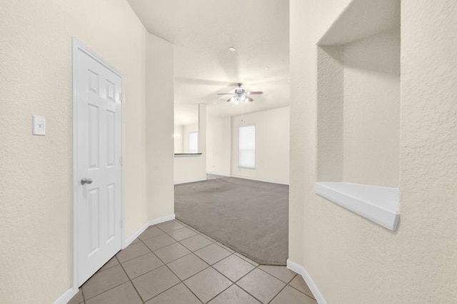 15806 Marble Bluff Ln, Houston, TX 77049 - hall with light carpet, light tile patterned floors, and a textured wall