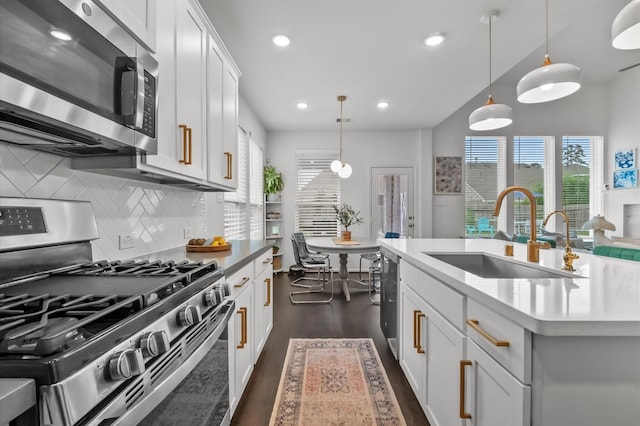 2824 Jehlon Ln, Conroe, TX 77385 - kitchen featuring stainless steel appliances, dark wood-style flooring, decorative backsplash, healthy amount of natural light, and recessed lighting