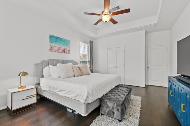 2824 Jehlon Ln, Conroe, TX 77385 - bedroom featuring a tray ceiling, dark wood-style floors, a closet, and ceiling fan