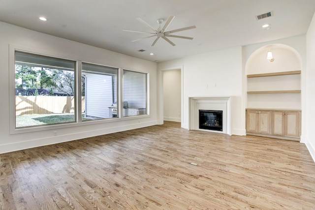 1514 Chantilly Ln, Houston, TX 77018 - unfurnished living room with light wood-style floors, ceiling fan, a glass covered fireplace, built in shelves, and recessed lighting