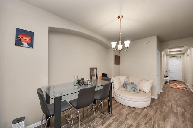 7947 Cinderella St, Houston, TX 77028 - dining area featuring arched walkways, wood finished floors, and a chandelier