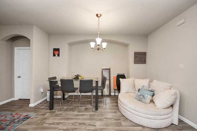7947 Cinderella St, Houston, TX 77028 - dining space featuring a chandelier, arched walkways, and wood finished floors