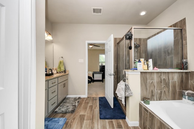 7947 Cinderella St, Houston, TX 77028 - ensuite bathroom featuring wood finish floors, a shower stall, vanity, a bath, and a ceiling fan