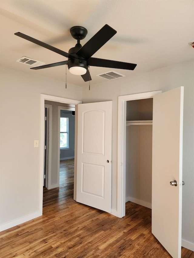 1719 Adina St, Austin, TX 78721 - unfurnished bedroom featuring wood finished floors, a closet, and ceiling fan