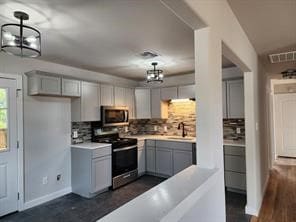 1719 Adina St, Austin, TX 78721 - kitchen featuring appliances with stainless steel finishes, gray cabinetry, decorative backsplash, and light countertops