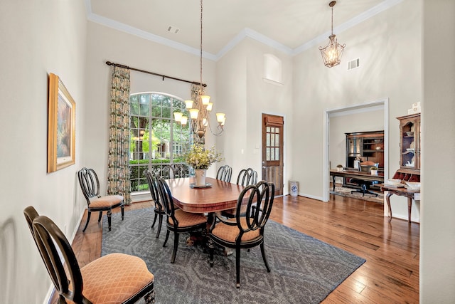 18331 Chapmans Count Rd, Cypress, TX 77433 - dining room featuring a chandelier, hardwood / wood-style flooring, crown molding, and a towering ceiling