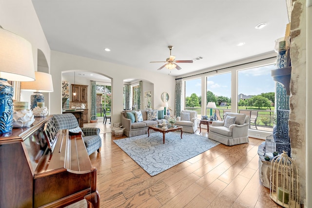 18331 Chapmans Count Rd, Cypress, TX 77433 - living room with arched walkways, plenty of natural light, a ceiling fan, light wood-type flooring, and recessed lighting