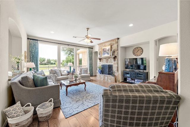18331 Chapmans Count Rd, Cypress, TX 77433 - living room with a fireplace, a ceiling fan, wood finished floors, and arched walkways