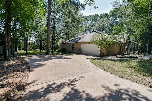 18110 Auburn Dr, Tomball, TX 77375 - view of home's exterior with concrete driveway, a garage, and brick siding