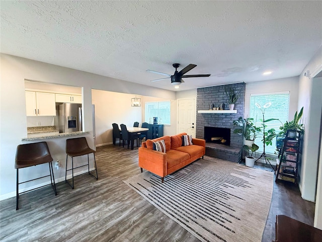 4822 Glendower Dr, Spring, TX 77373 - living area with a ceiling fan, dark wood finished floors, a textured ceiling, and a brick fireplace