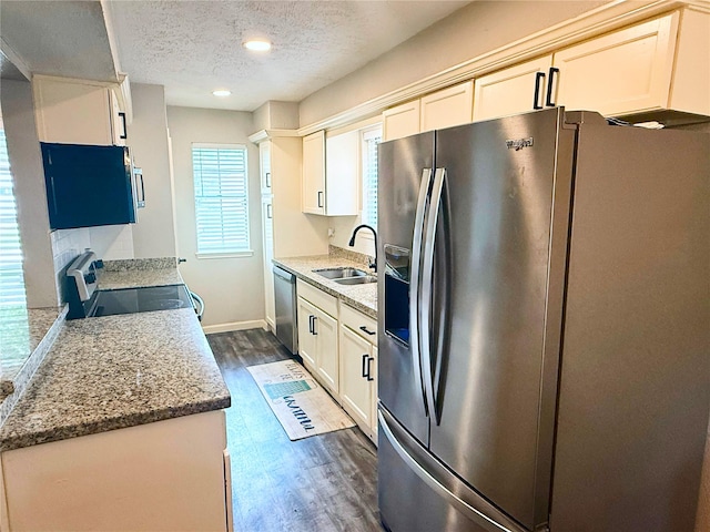 4822 Glendower Dr, Spring, TX 77373 - kitchen with appliances with stainless steel finishes, dark wood-style floors, a textured ceiling, recessed lighting, and light stone counters
