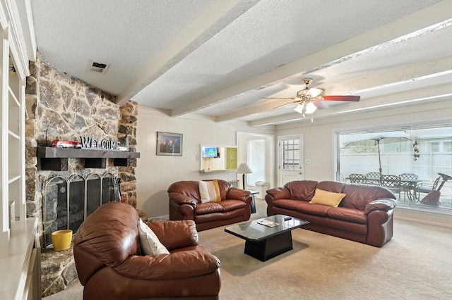2910 Riata Ln, Houston, TX 77043 - living area with a textured ceiling, carpet flooring, beamed ceiling, ceiling fan, and a stone fireplace